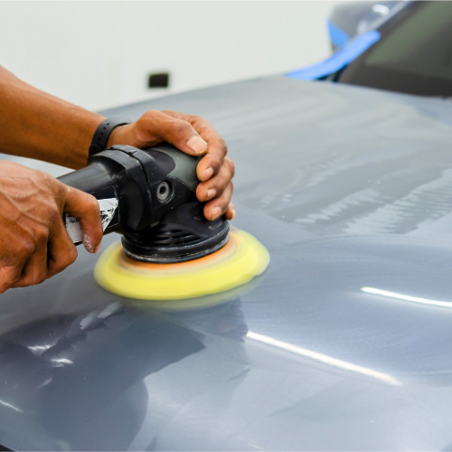 Lavage extérieur minutieux d'une voiture rouge à l'aide d'une éponge